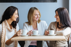Three female friends having coffee in a cafe