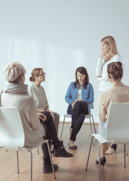 5 women sitting in seats in a women's group therapy session