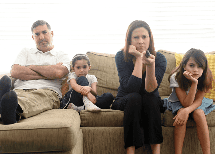 Family looking unhappy watching the TV before family therapy