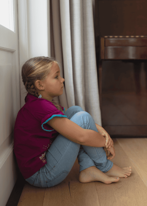 Young girl sitting on her own in need of child therapy sessions