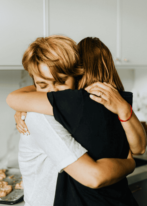 Mother hugging her teenage daughter after teen therapy